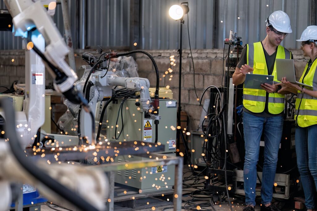 In robotic maintenance shop engineer busy commissioning and operate robot arm welding spark